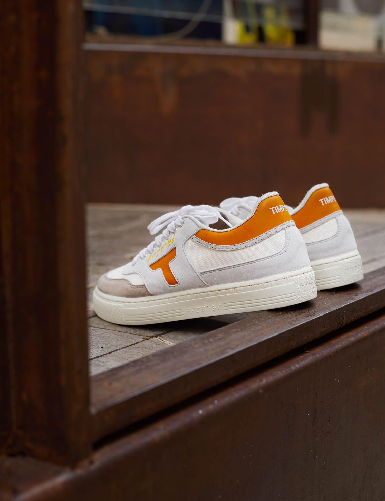 Zapatilla de hombre y mujer. Zapatilla unisex. Zapatilla de estilo más deportivo. El color que predomina es el mostaza y blanco .La zapatilla tiene detalles en blanco. Los cordones son color blanco al igual que la suela.