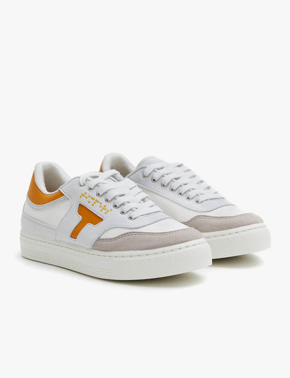 Zapatilla de hombre y mujer. Zapatilla unisex. Zapatilla de estilo más deportivo. El color que predomina es el mostaza y blanco .La zapatilla tiene detalles en blanco. Los cordones son color blanco al igual que la suela.