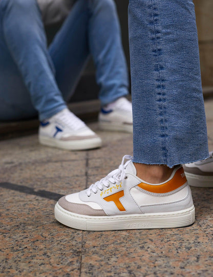 Zapatilla de hombre y mujer. Zapatilla unisex. Zapatilla de estilo más deportivo. El color que predomina es el mostaza y blanco .La zapatilla tiene detalles en blanco. Los cordones son color blanco al igual que la suela.